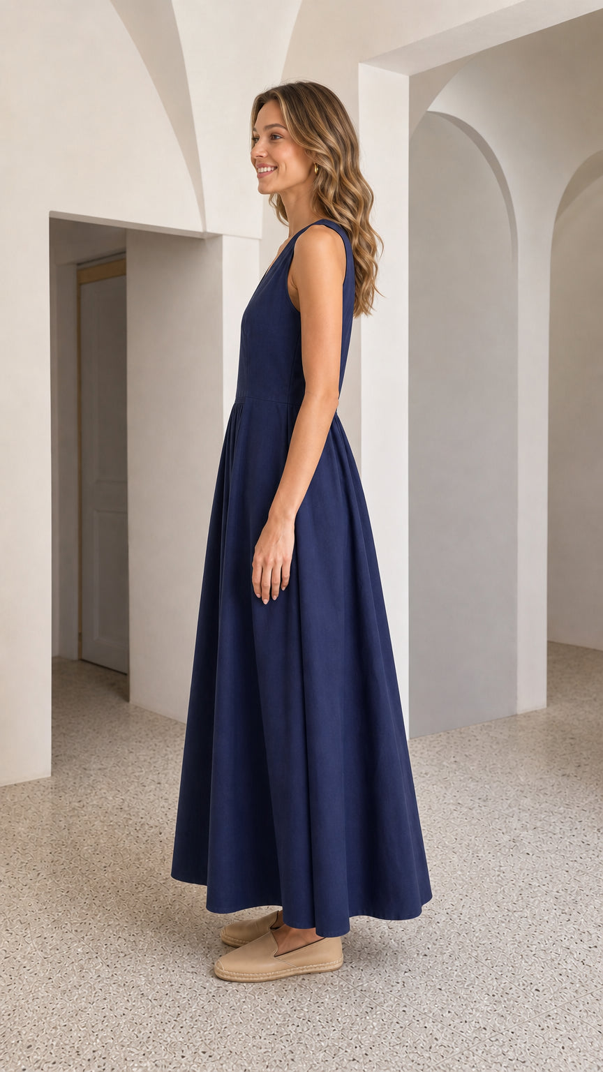 Side view of woman in navy maxi dress showing flowing skirt drape