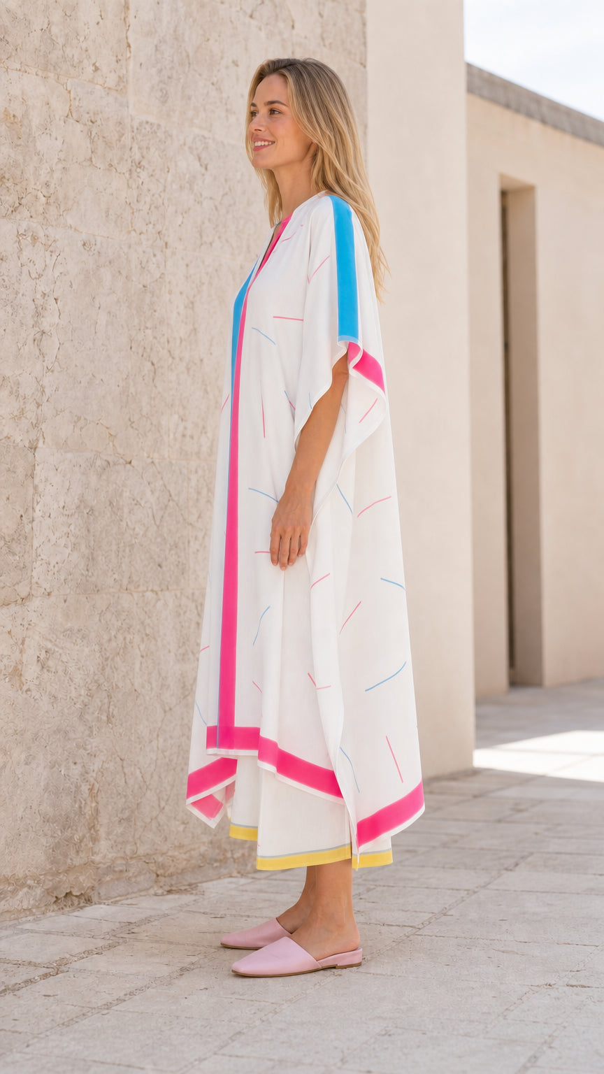 Side profile view of model in white kaftan maxi dress