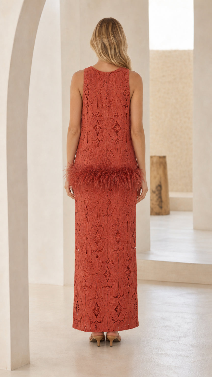 Back view of model wearing rust maxi dress with feather detail