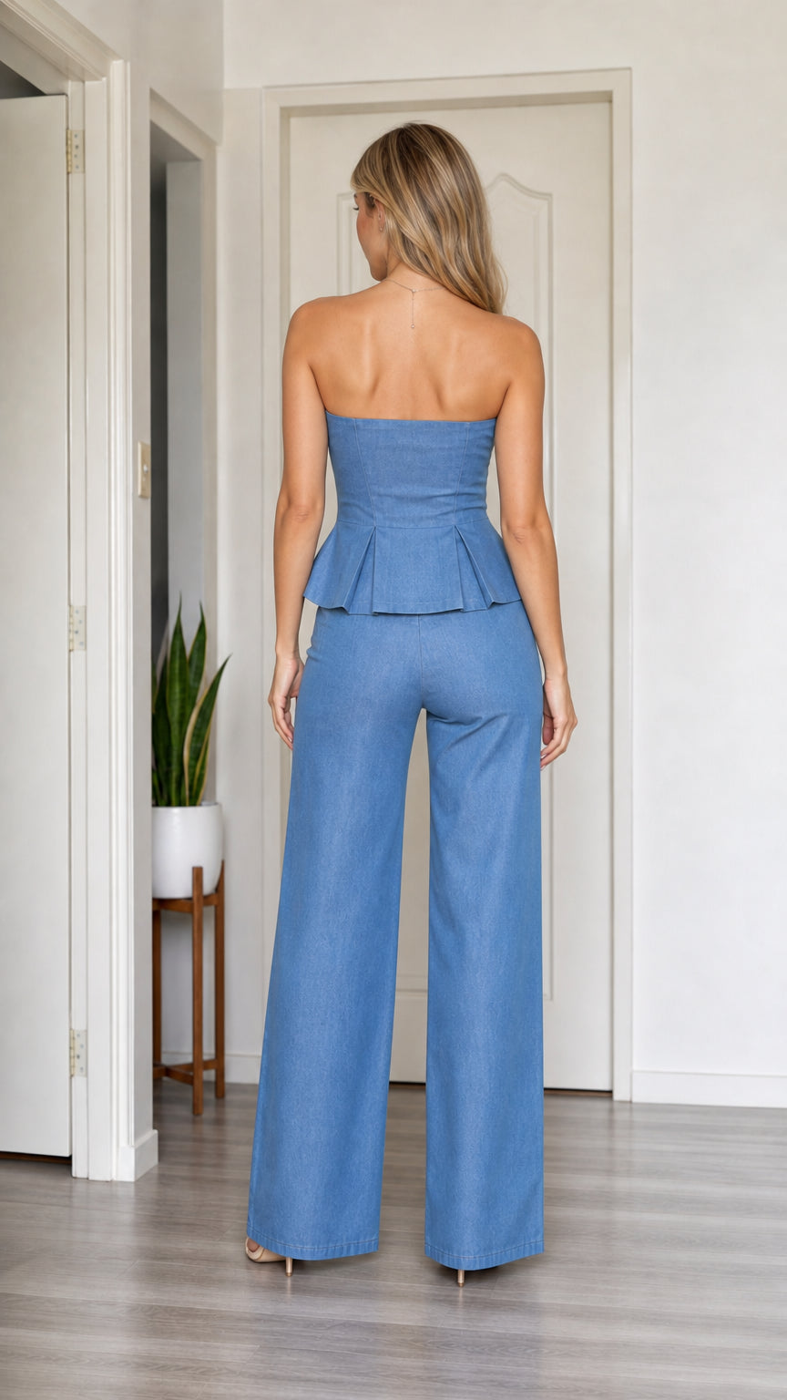 Back view of model in blue peplum top and trousers