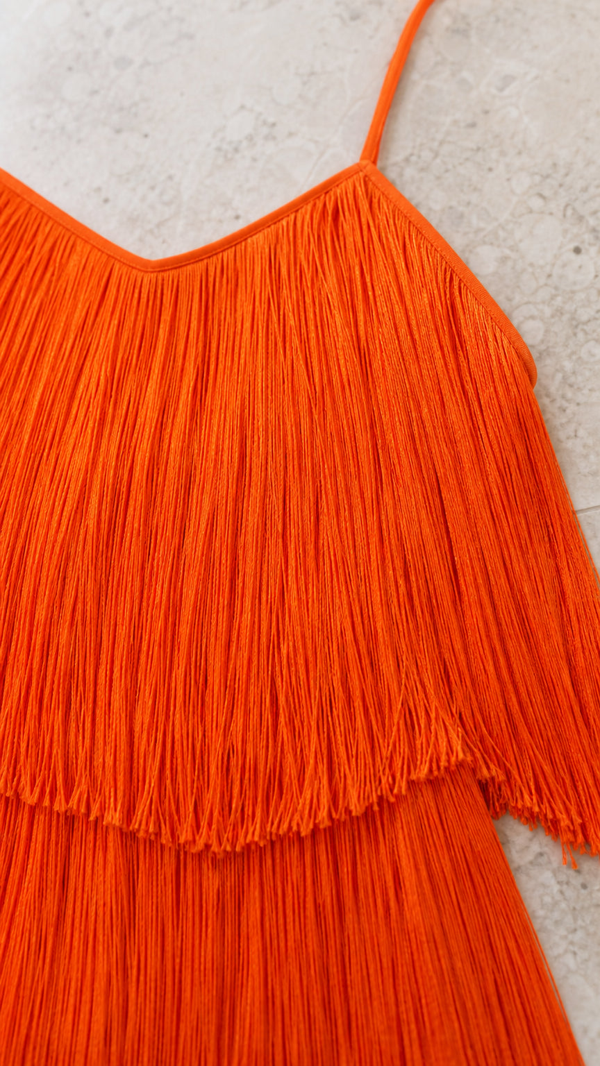 Close-up detail of orange fringe layers and spaghetti straps
