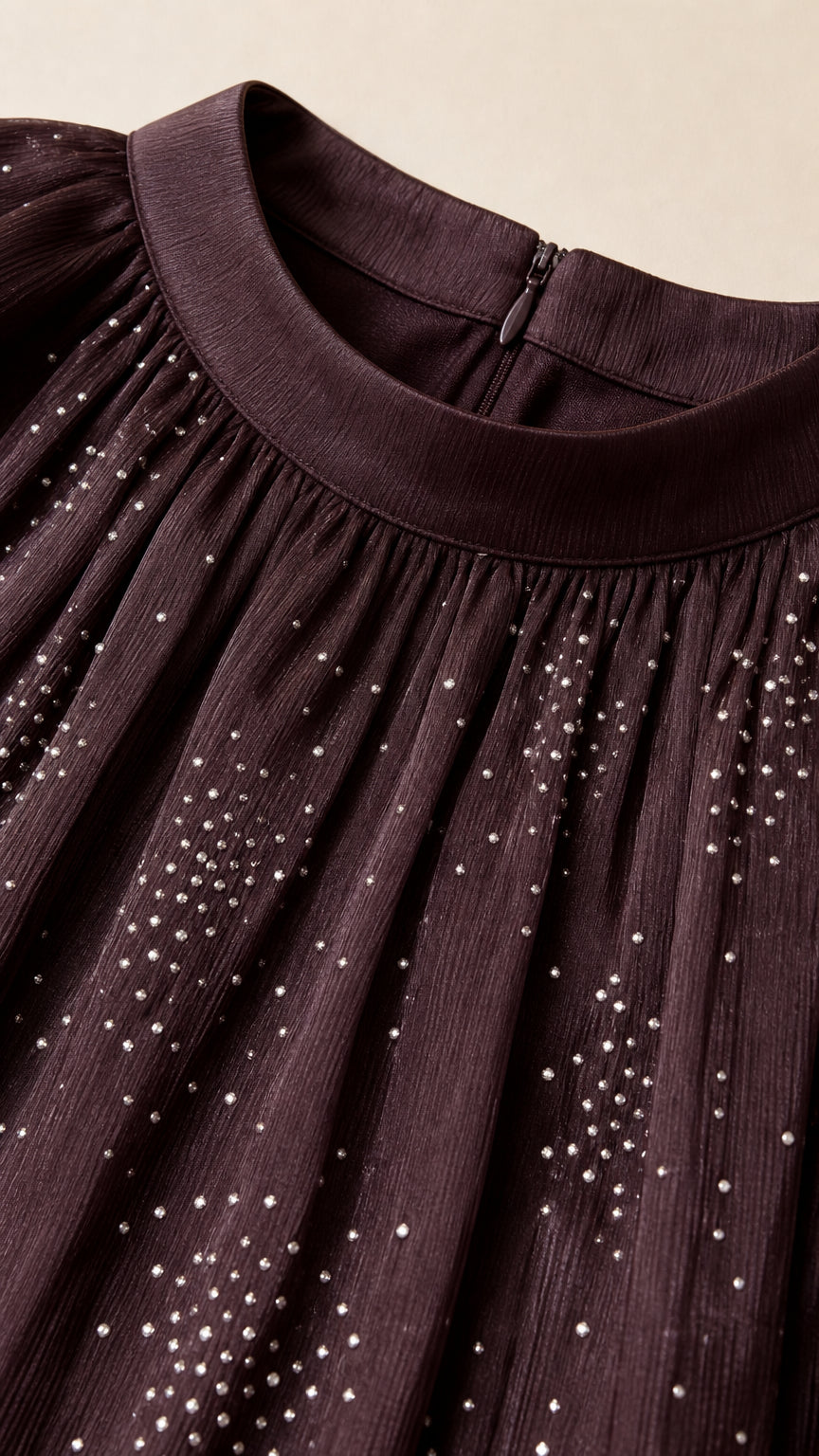 Close-up of halter neckline and glitter detailing on brown fabric