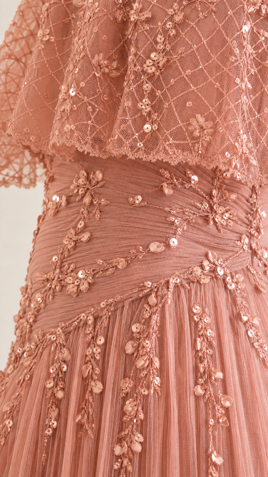 Close-up detail of sequin embroidery on the bodice and cape of rose pink dress
