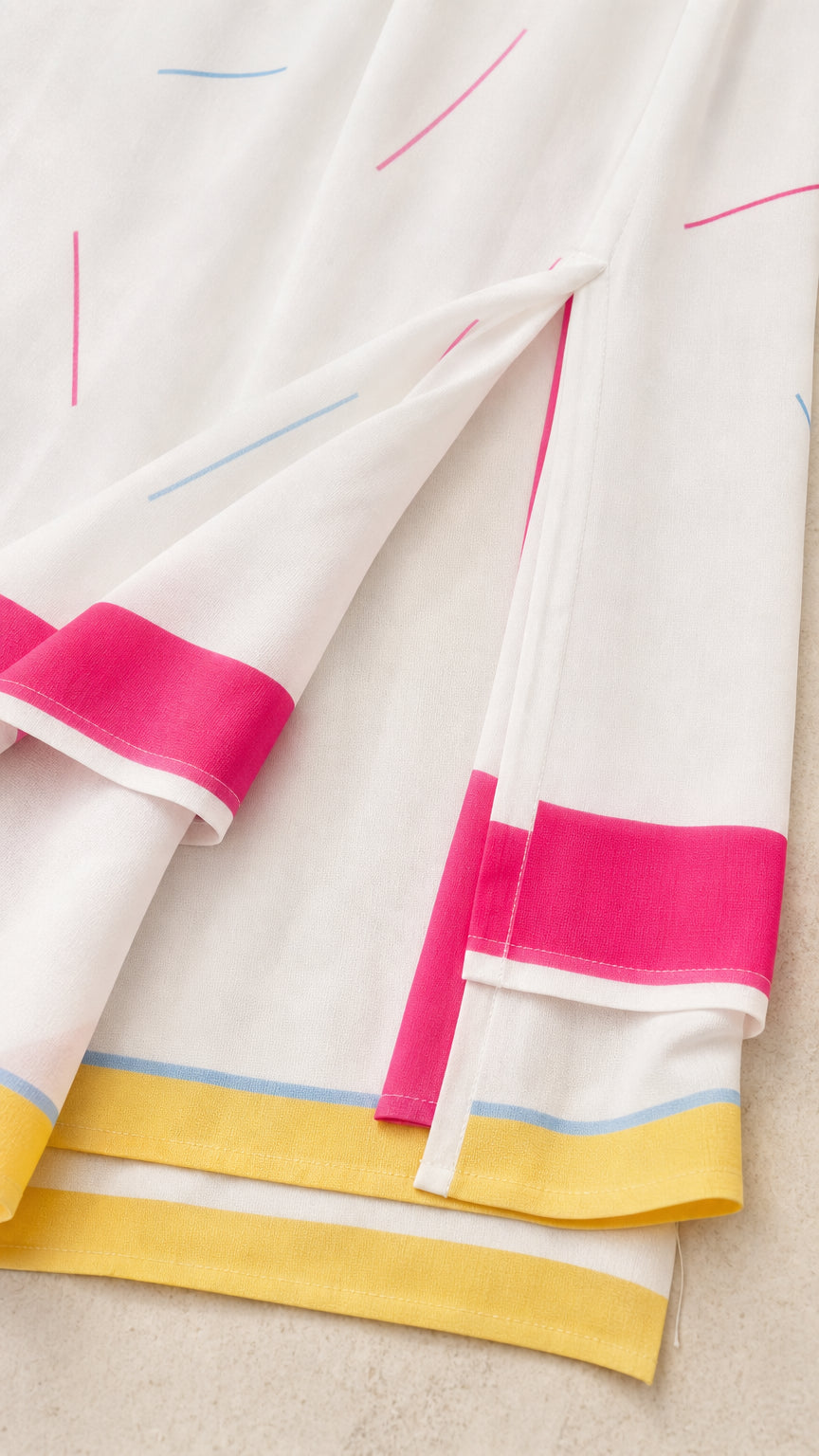 Close-up detail of fabric texture and hem on white kaftan dress
