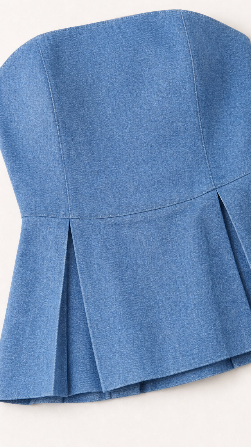 Close-up detail of pleated peplum hem on blue top