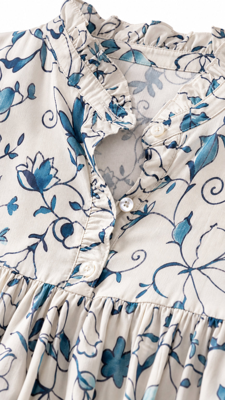 Close-up detail of ruffle collar and button placket on floral dress