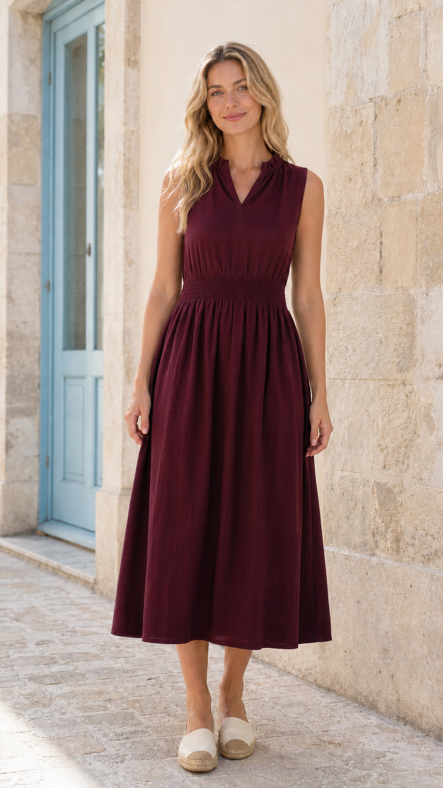 Full front view of woman wearing burgundy sleeveless smocked midi dress